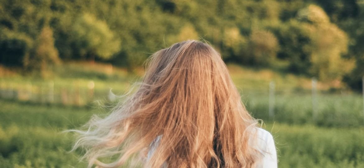 selective focus photo of woman facing grass field